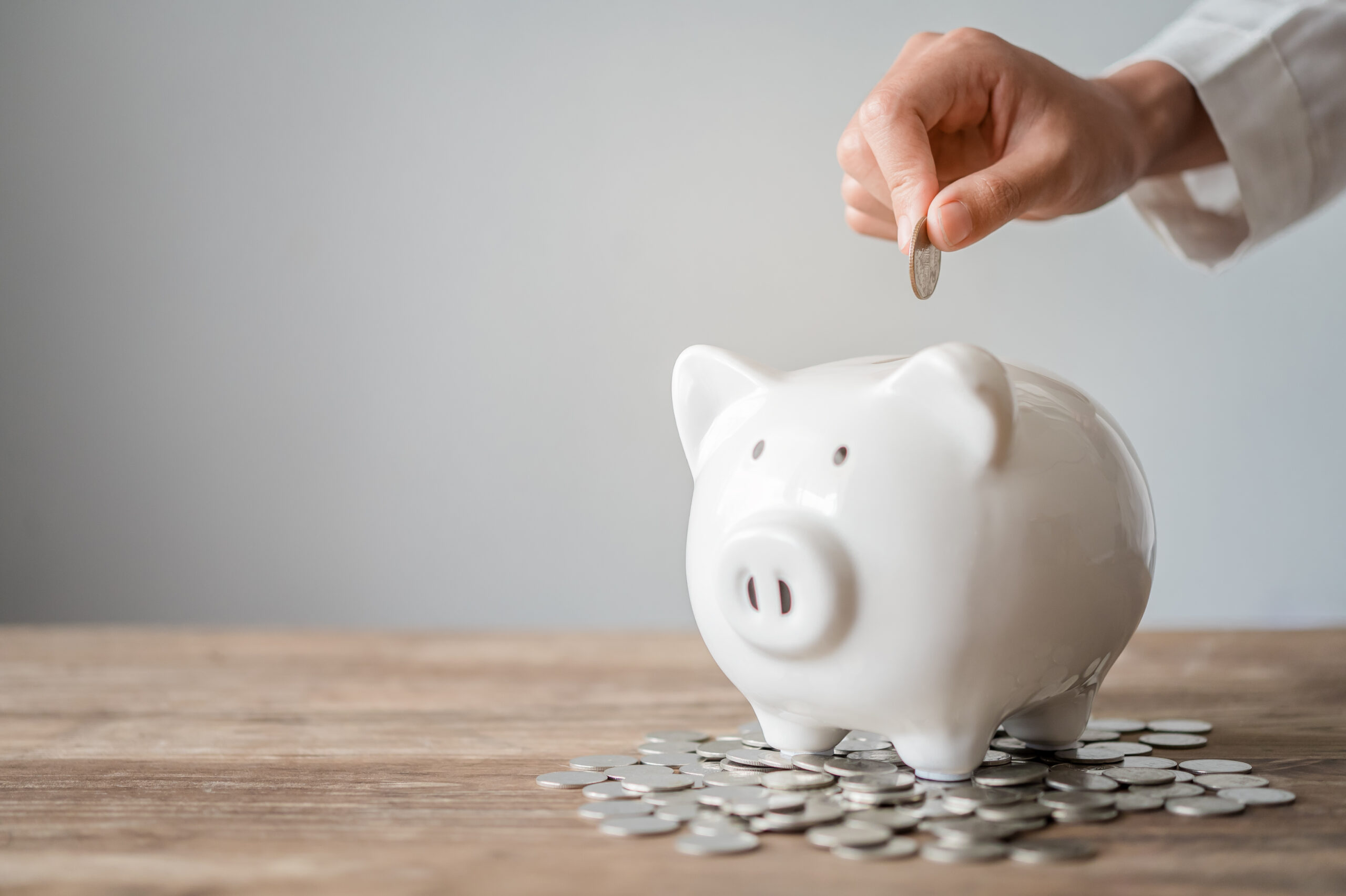 Hand holding coin with pig piggy bank. Saving and financial accounts concept